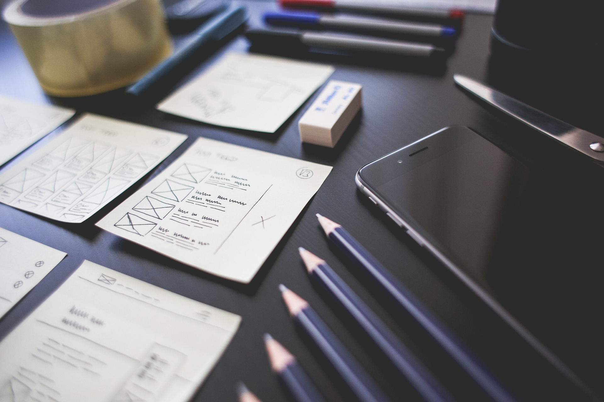 papers, pencils, and a phone neatly arranged on a dark wooden desk